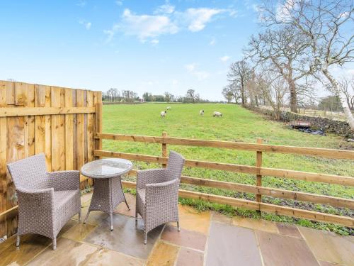a patio with a table and chairs and a fence at Mabels Stable in Clitheroe