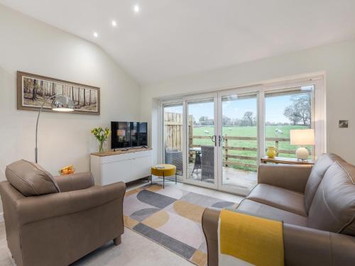 a living room with a couch and a tv at Mabels Stable in Clitheroe