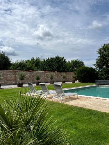 a group of chairs sitting next to a swimming pool at Hotel Garni Klaret in Valtice