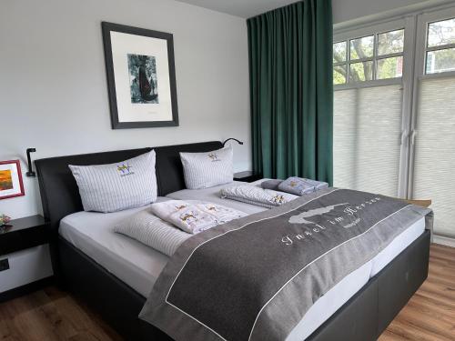 a bedroom with a large bed with green curtains at Insel-Juwel im Lindenhof in Wangerooge