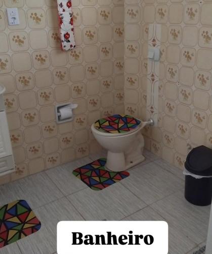 a bathroom with a toilet with a colorful tile floor at Ap do Edney Águas de Lindoia in Águas de Lindoia