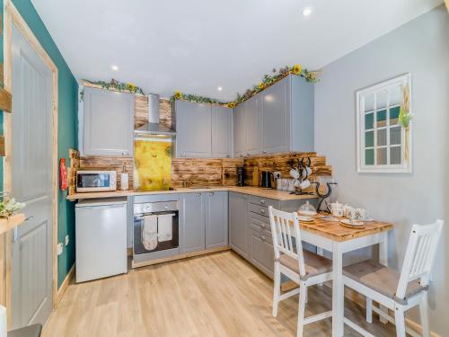 a kitchen with a table and a table and chairs at Coachmans Cottage - Uk50418 in Bisterne