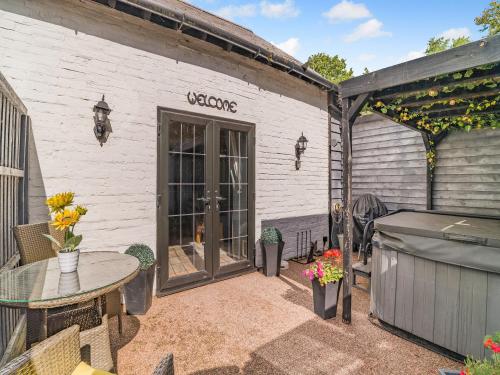 a patio with a table and a building at Coachmans Cottage - Uk50418 in Bisterne