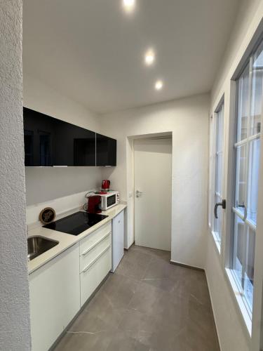 a white kitchen with a sink and a microwave at Apartment for 4 in Cairo Montenotte
