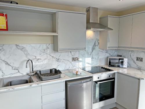a kitchen with white appliances and marble counter tops at Willow Cottage - Uk51376 in Winston