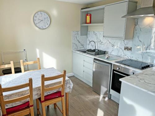 a kitchen with a table and a clock on the wall at Willow Cottage - Uk51376 in Winston