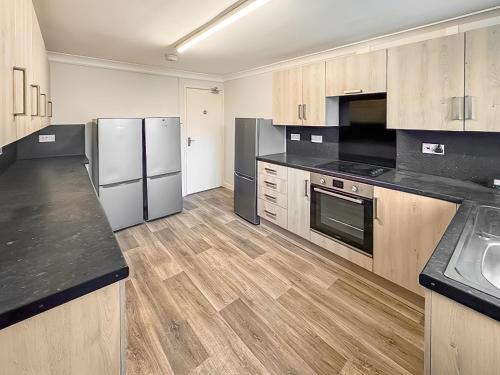 a kitchen with stainless steel appliances and wooden cabinets at Riverside Cottage in Spalding