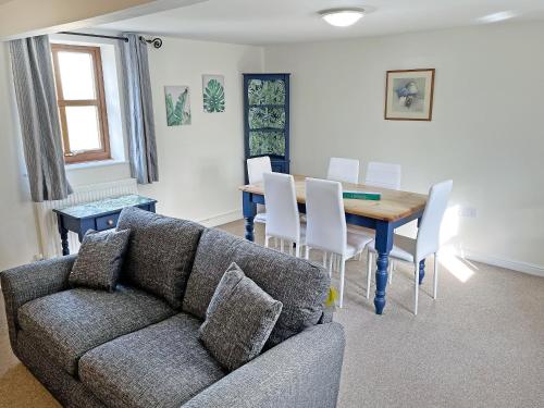 a living room with a couch and a table and chairs at Ivy Cottage - Uk51372 in Winston