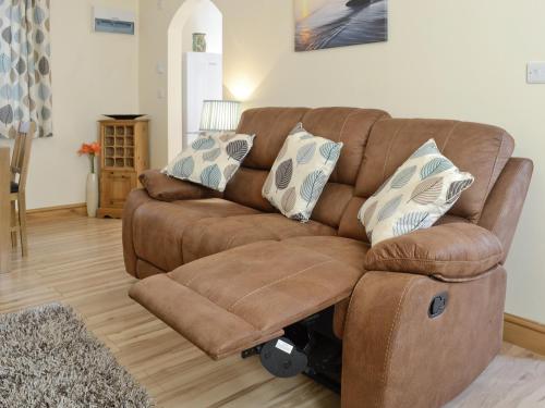 a brown couch with pillows on it in a living room at Hen Ysgubor - 29518 in Fairbourne