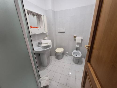 a white bathroom with a toilet and a sink at Tiber Domus Trevignano in Trevignano Romano