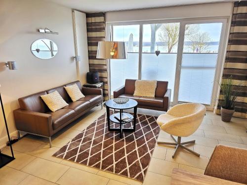 a living room with a couch and a chair at Ferienhaus Villa Seeblick - ABC223 in Bad Kleinen