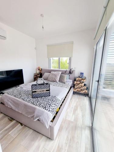 a white bedroom with a bed and a window at luxury villa utopia 2 in Paphos