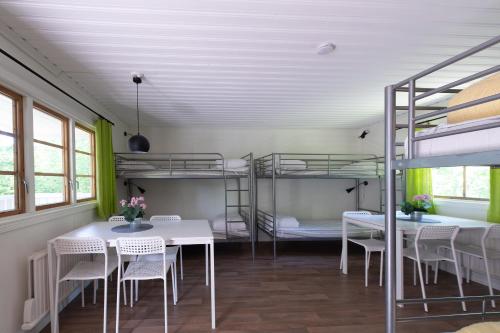 a room with two bunk beds and tables and chairs at Djulöcamping in Katrineholm