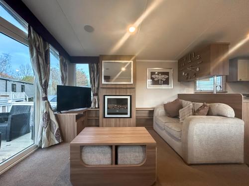 a living room with a couch and a table at Simon's Coastal Holiday Home in Ormesby Saint Margaret
