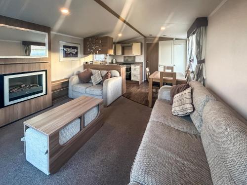 a living room with a couch and a table at Simon's Coastal Holiday Home in Ormesby Saint Margaret