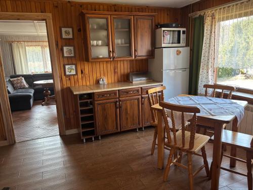 a kitchen with a table and a refrigerator at Chata Baśka in Baligród