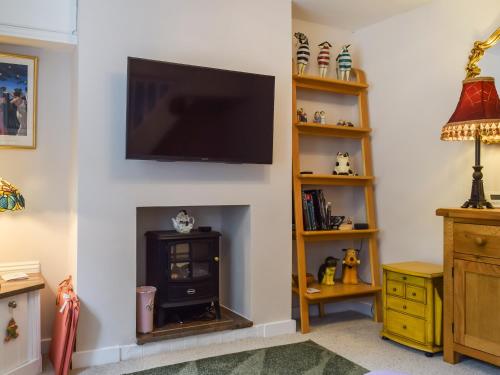 a living room with a fireplace with a flat screen tv at Spire View Cottage in Olney