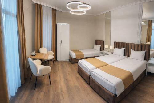 a hotel room with two beds and a table and chairs at Pensiunea Brici in Cluj-Napoca