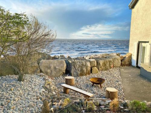 a bench and some rocks and the ocean at Redgauntlet in Skinburness