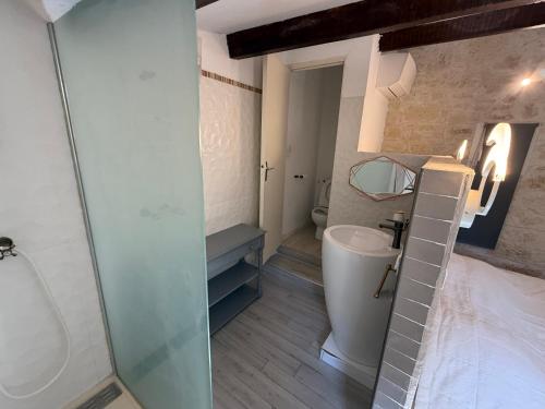 a bathroom with a toilet and a sink and a mirror at La Laurisienne in Lauris