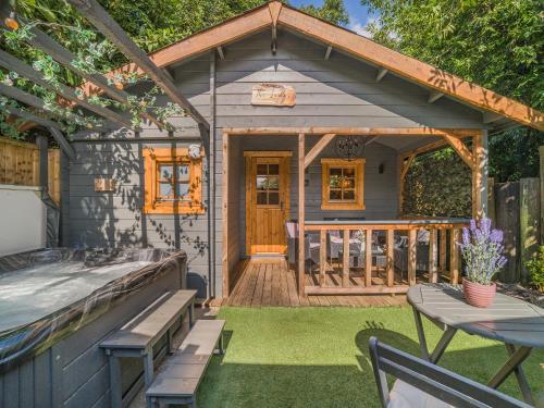 a tiny house with a deck and a table at The Lodge - Uk50409 in Bisterne