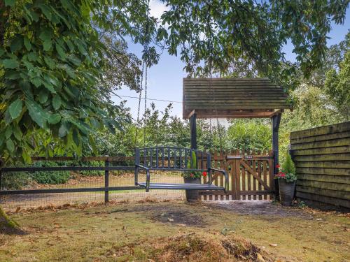 a gazebo with a bench next to a fence at The Lodge - Uk50409 in Bisterne