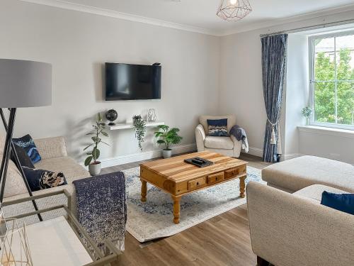 a living room with a couch and a coffee table at Airds Apartment in Oban