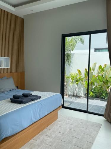 a bedroom with a bed and a large glass window at Vela Villa Aonang in Ban Chong Phli