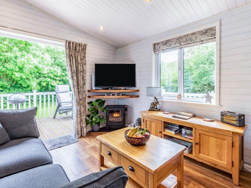 a living room with a couch and a tv at Lavender Lodge in Derby