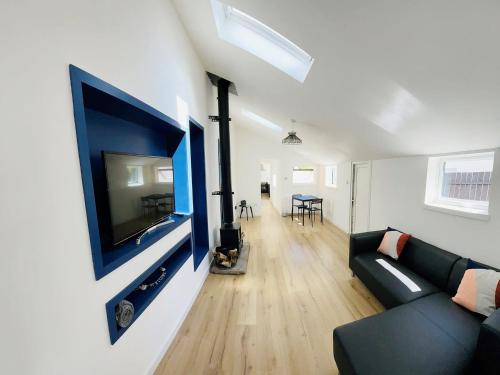 a living room with a large flat screen tv on a wall at Ardrhu Cottage in Hunters Quay