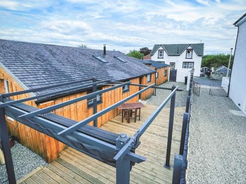 a large wooden deck with a table and a building at Ardrhu Cottage in Hunters Quay