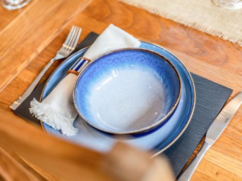 a blue plate on a table with a fork and knife at Lavender Lodge in Derby