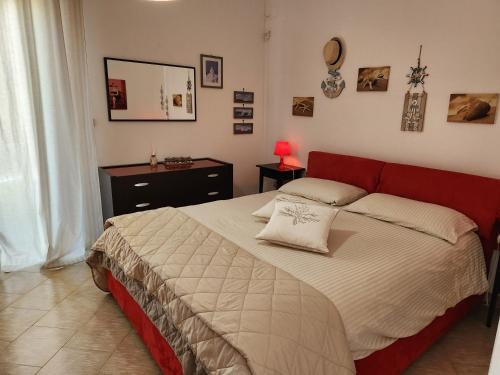 a bedroom with a large bed with a red headboard at Appartamenti Baia Azzurra in Leuca
