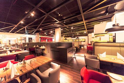 a restaurant with a long wooden table and chairs at See und Sporthotel Ankum mit Lakeside Apartments in Ankum