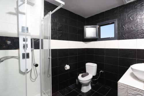 a black and white bathroom with a toilet and a shower at Hilltop Chalet 4 in Hanioti