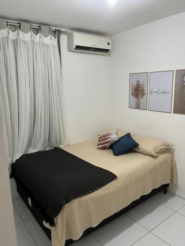 a bedroom with a large bed with a window at Ap à 600 metros da praia, um verdadeiro paraíso! in Barra dos Coqueiros