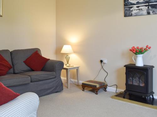 a living room with a couch and a stove at Elm Court 7 in Keswick