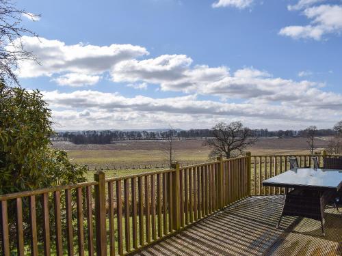 a wooden deck with a picnic table and a fence at Lime Tree Cottage in Oakley