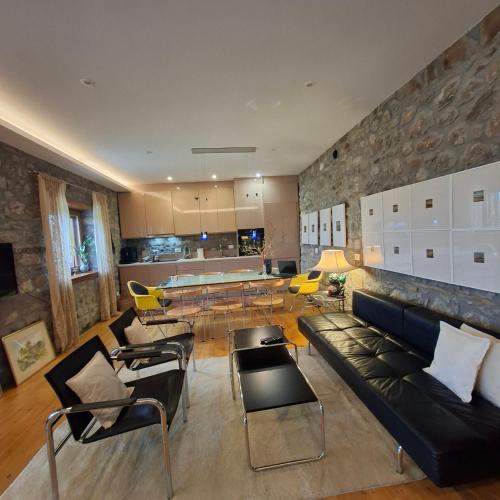 a living room with a couch and a table and chairs at 7 Roots - Leskovik in Leskovik