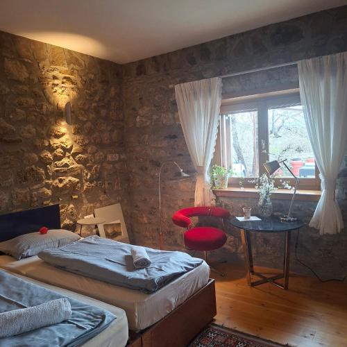 a bedroom with two beds and a table and a window at 7 Roots - Leskovik in Leskovik