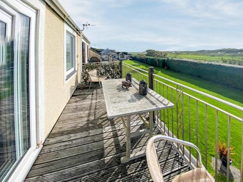 a wooden deck with a table and chairs on a balcony at Mill Cottage in Aberdyfi