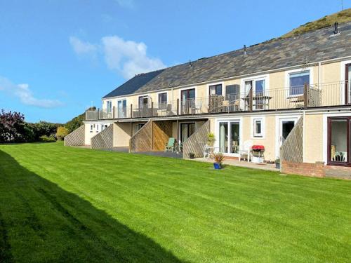 a large house with a lawn in front of it at Mill Cottage in Aberdyfi