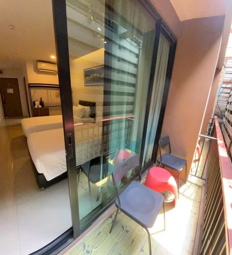 a balcony with a room with a bed and a window at Red Door Samsen Hotel, Bangkok in Bangkok