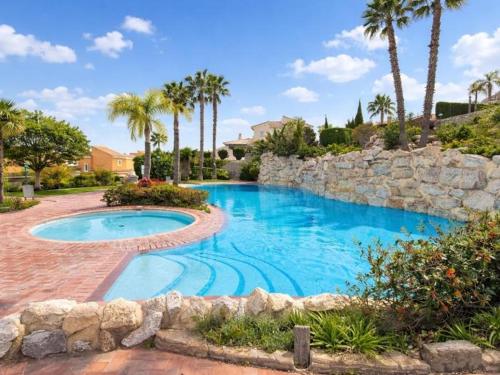 a swimming pool in a yard with palm trees at Casa Relax in Polop - Jacuzzi and Pool in Polop