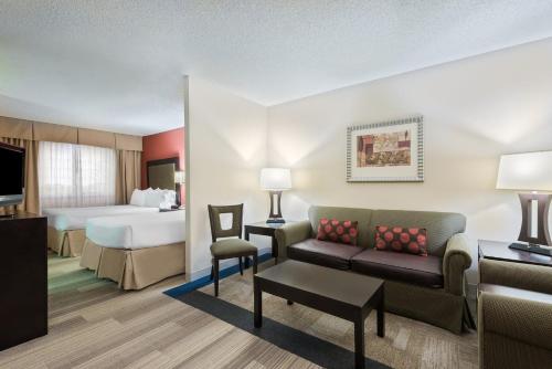 a hotel room with a couch and a bed at Holiday Inn Express Hotel & Suites Kendall East-Miami by IHG in Kendall