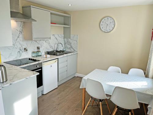 a kitchen with a table and a clock on the wall at Elder Cottage - Uk51371 in Winston