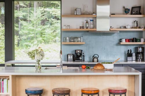 a kitchen with a counter with stools and a table at Sterling Treehouse in Stowe Fork
