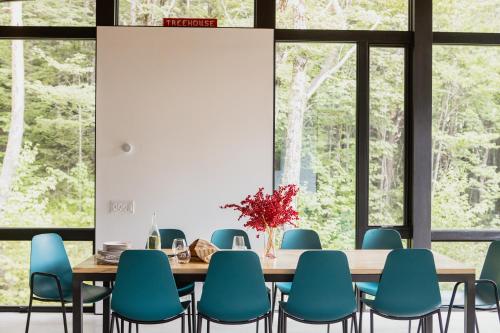 a dining room with a table and blue chairs at Sterling Treehouse in Stowe Fork