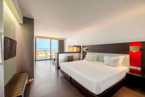 a hotel room with a bed and a balcony at RR Hotel da Rocha in Portimão