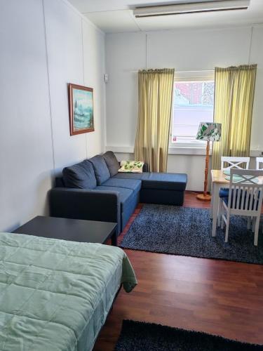a living room with a blue couch and a table at Huone 2-4 henkilölle Inkoossa in Inkoo